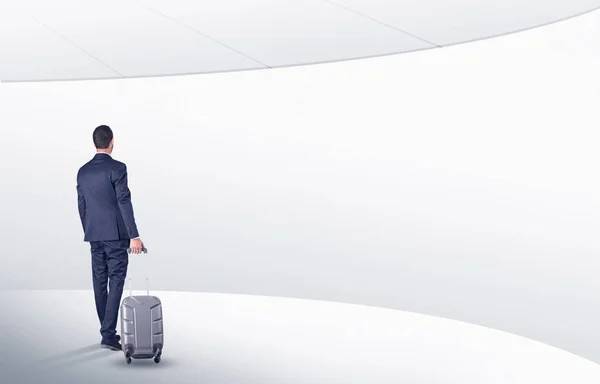 Бізнесмен з валізою, що йде в кімнаті очікування — стокове фото