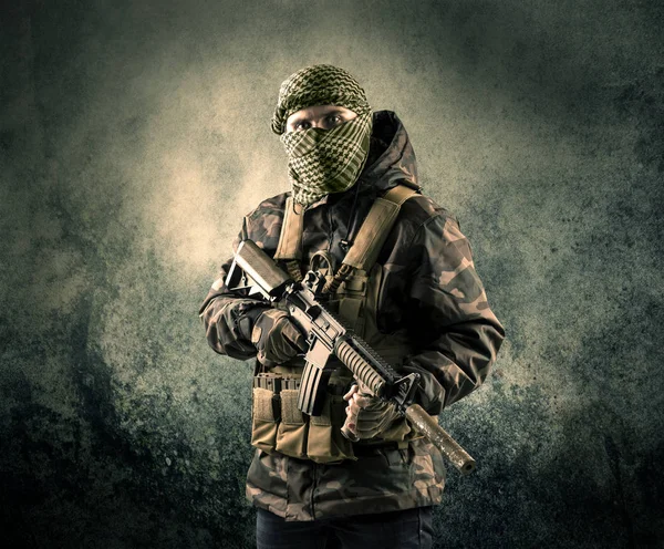 Porträt eines schwer bewaffneten, maskierten Soldaten mit grundiertem Hintergrund — Stockfoto