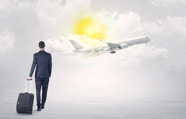 Бизнесмен с багажом идет к самолету — стоковое фото