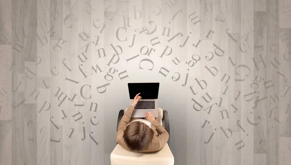 Letras com mulher usando laptop em uma cadeira — Fotografia de Stock