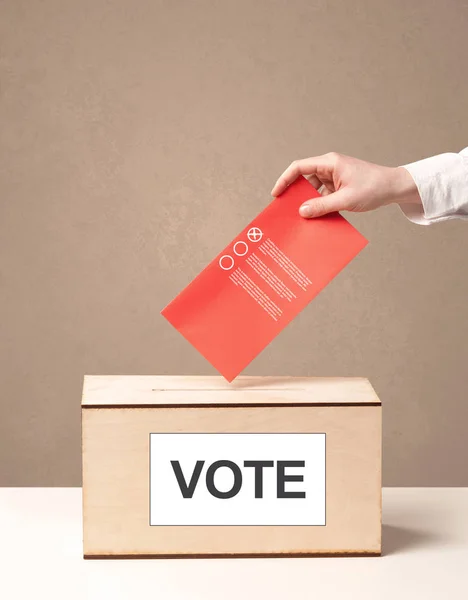 Close up of male hand putting vote into a ballot box