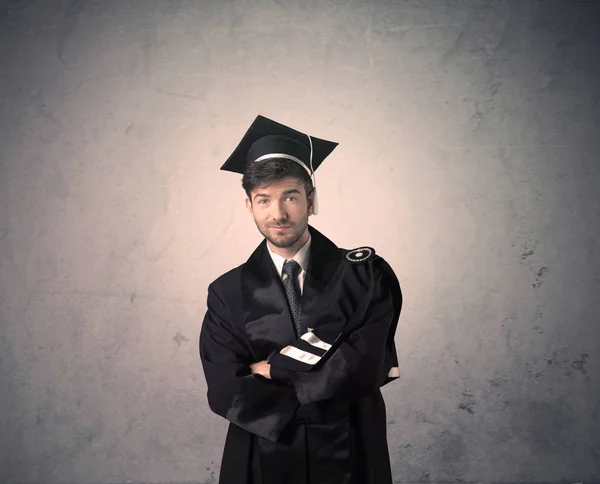 Portret van een jonge afgestudeerde student op grungy achtergrond — Stockfoto