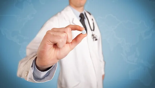 Doctor in white holding a pill — Stock Photo, Image