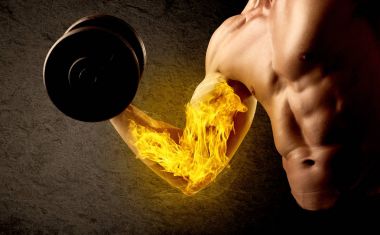 Kaslı vücut geliştirici alevli pazı konseptiyle ağırlık kaldırıyor.