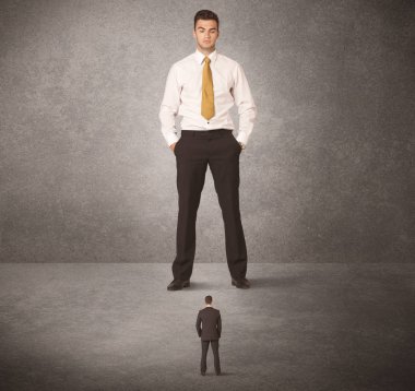 Büyük iş adamı küçük işçilere bakıyor.