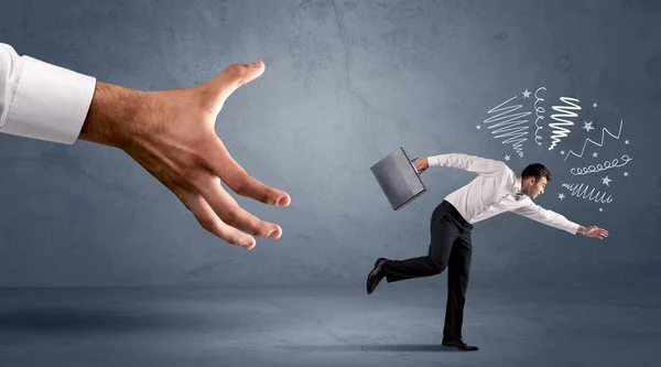 Stressful businessman running from a big hand — Stock Photo, Image