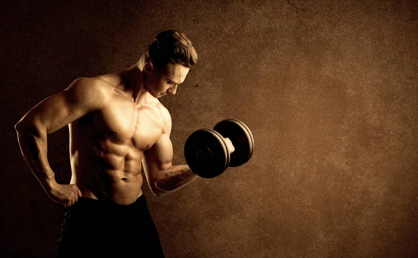 Kas formundaki vücut geliştirici sporcu ağırlık kaldırıyor 