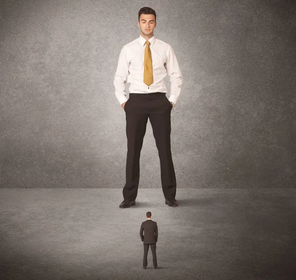 Büyük iş adamı küçük işçilere bakıyor.