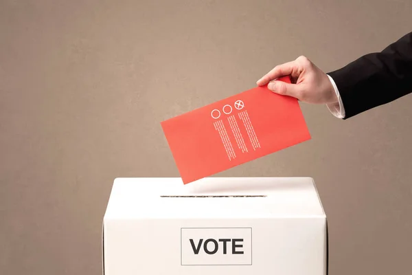 Close up of male hand putting vote into a ballot box — Stock Photo, Image