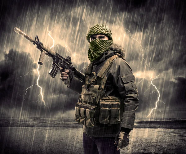 Gefährlicher bewaffneter Terrorist mit Maske und Waffe im Gewitter — Stockfoto