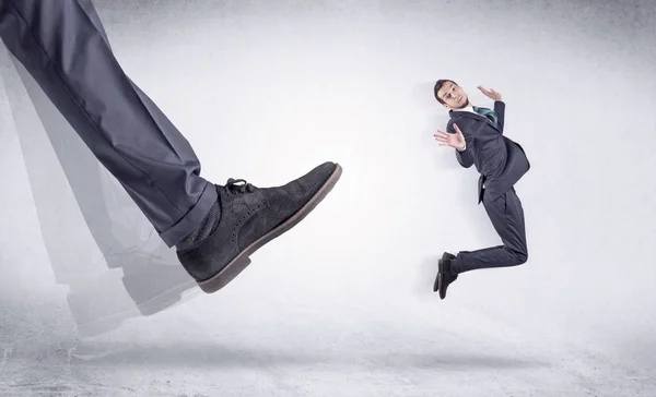 Sapato preto chutando homem pequeno — Fotografia de Stock