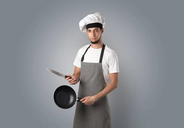 Кухар з кухонними інструментами і порожніми шпалерами — стокове фото
