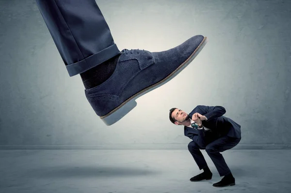 Employee getting trampled by big shoe — Stock Photo, Image