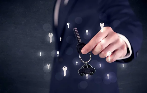 Empresario sosteniendo llaves con llaves alrededor — Foto de Stock