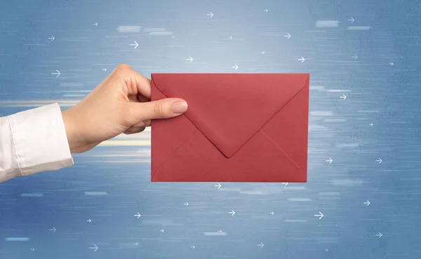 Hand holding envelope with arrows around