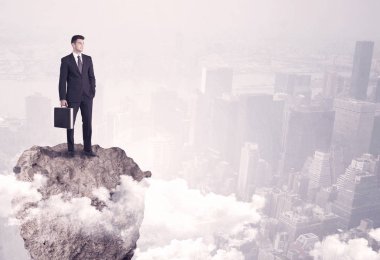 Kayanın üzerinde duran kazanan iş kişi