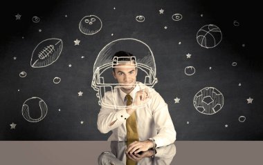 İş adamı miğfer ve spor topu çiziyor.