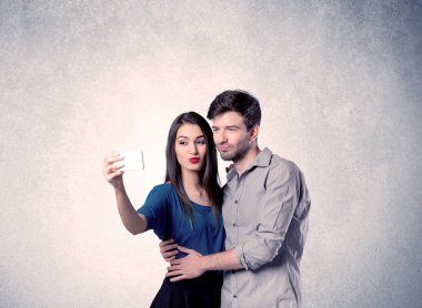 Mutlu çift temiz duvarlı selfie çekiyor.