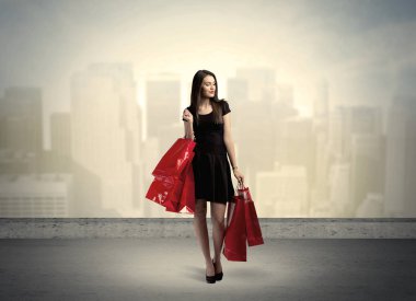 Alışveriş torbalarıyla duran şehir kadını.