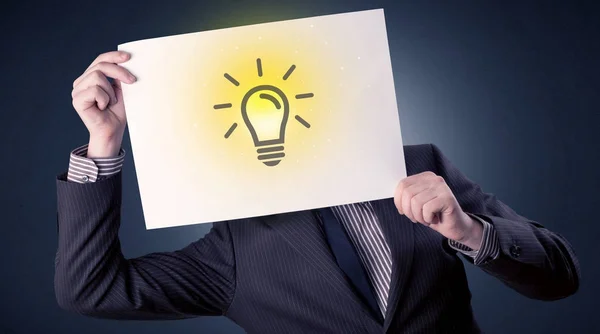 Businessman holding paper with lightbulb — Stock Photo, Image