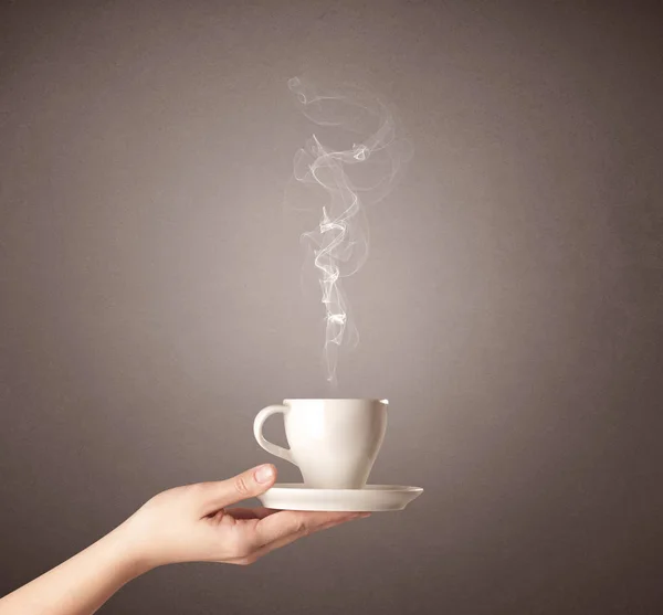 Vrouwelijke hand bedrijf koffie beker — Stockfoto