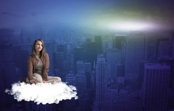 Mujer sentada en la nube sobre la ciudad — Foto de Stock