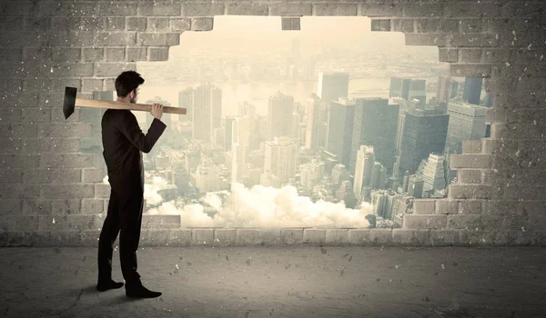 Üzletember üt fal kalapács a városra néző — Stock Fotó