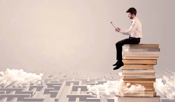 Uomo con tablet seduto sui libri — Foto Stock