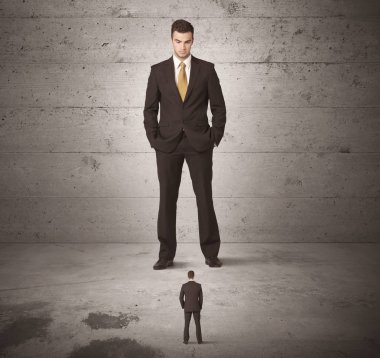 Büyük bir iş adamı küçük bir iş arkadaşına bakıyor.