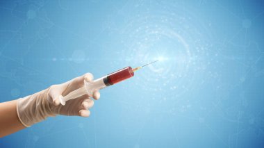 Kadın doktor elinde şırınga tutuyor.