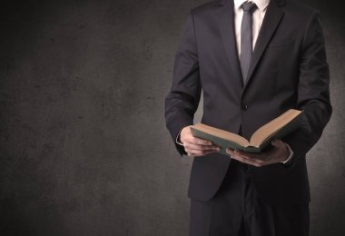 Elinde kitap tutan bir işadamı