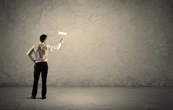 Vendeur avec rouleau debout au mur vide — Photo