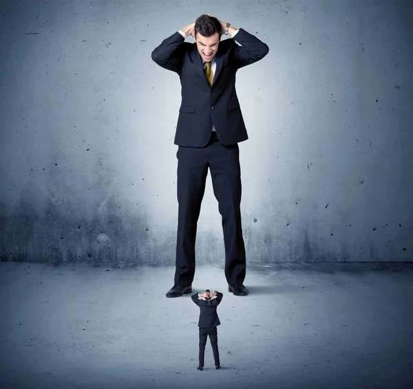 Öfkeli büyük iş adamı küçük adama lokma atıyor.