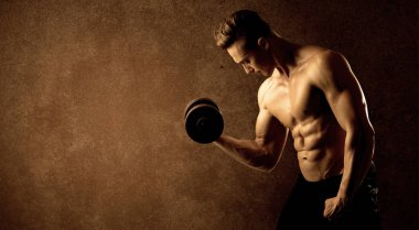 Kas formundaki vücut geliştirici sporcu ağırlık kaldırıyor 