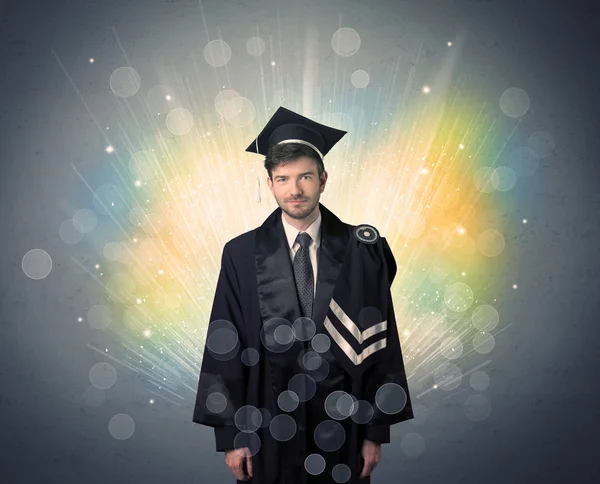 Feliz graduado con luces bokeg de colores en el fondo — Foto de Stock