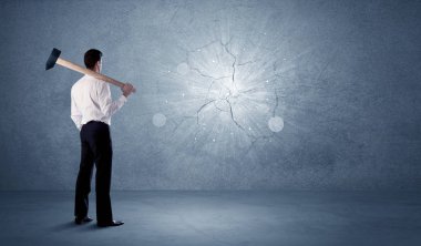 İşadamı çekiçle duvara çarpıyor.