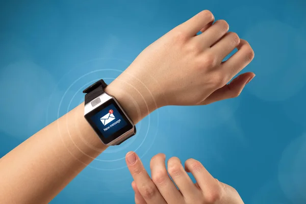 Mão com smartwatch e fundo azul — Fotografia de Stock