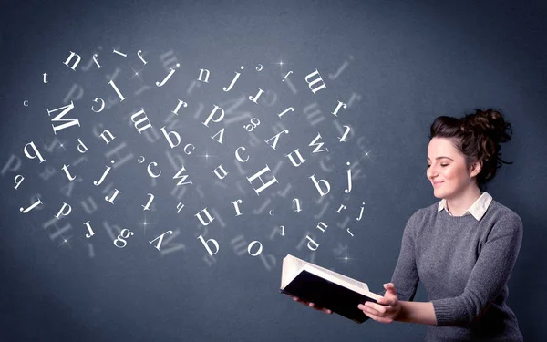 Jovem senhora segurando livro com letras — Fotografia de Stock