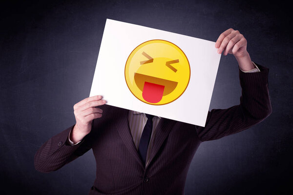 Businessman holding paper with emoticon 
