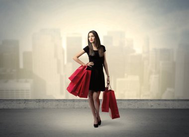 Alışveriş torbalarıyla duran şehir kadını.