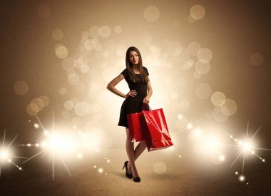 Parlak ışıklarda çantalı alışveriş yapan kadın.