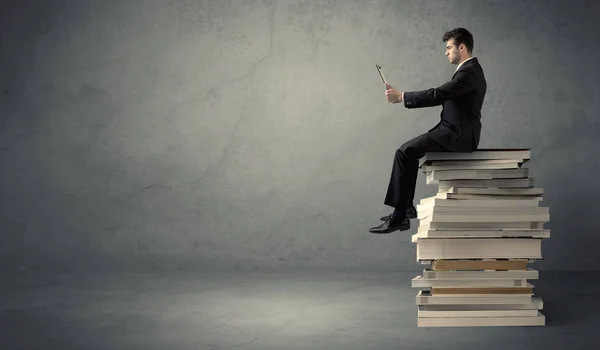 Étudiant assis sur une pile de livres — Photo