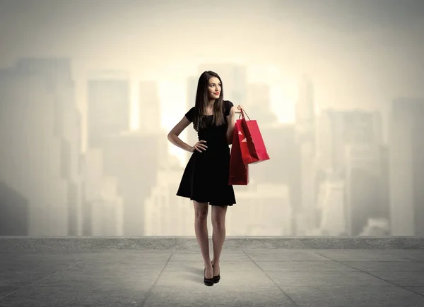 Elegantní město dívka s červenými nákupními taškami — Stock fotografie