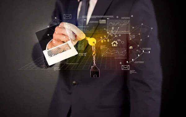 Businessman holding keys with graphs around — Stock Photo, Image