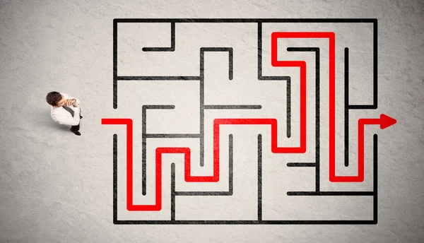 Uomo d'affari perduto trovato la strada nel labirinto con freccia rossa — Foto Stock