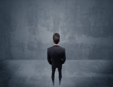 Şehir duvarının önünde duran iş adamı