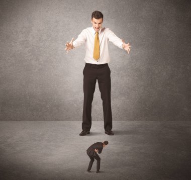 Büyük iş adamı küçük işçilere bakıyor.