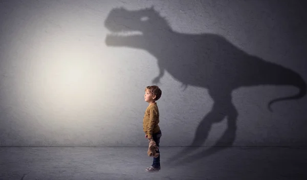 Тень динозавра позади симпатичного мальчика — стоковое фото