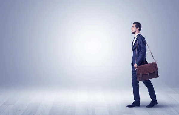 Empresario caminando frente a una pared vacía — Foto de Stock