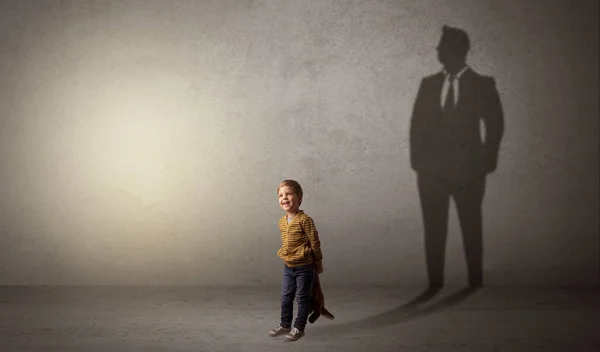 Мальчик с тенью бизнесмена — стоковое фото